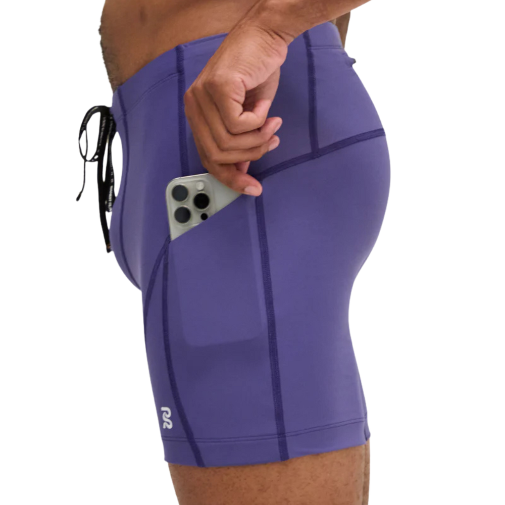 Purple athletic shorts with a pocket holding a phone on a white background